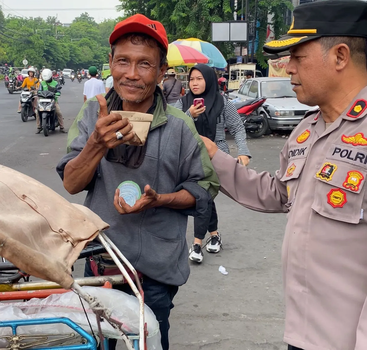 Kapolsek Simokerto Lakukan Aksi Sosial Dengan Berbagi 100 Nasi Bungkus Kepada Masyarakat Sambil Himbau Pengendara Motor Tak Pakai Helm
