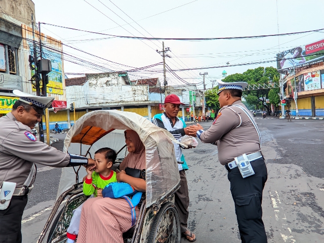 Jelang Nataru Polres Lumajang Beri Edukasi Masyarakat Tertib Lalu Lintas Sambil Berbagi Nasi Bungkus