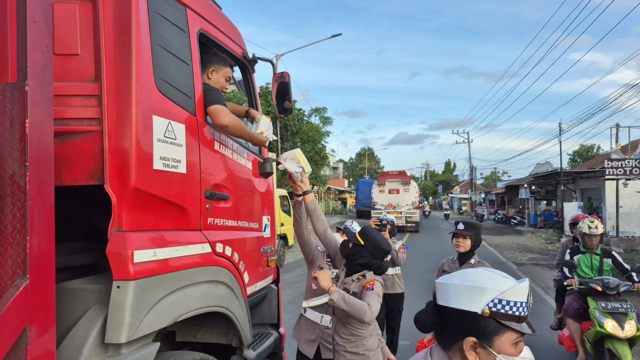 Polresta Banyuwangi Berbagi Mamiri Kepada Pengguna Jalan yang Terjebak Kepadatan Pelabuhan Ketapang