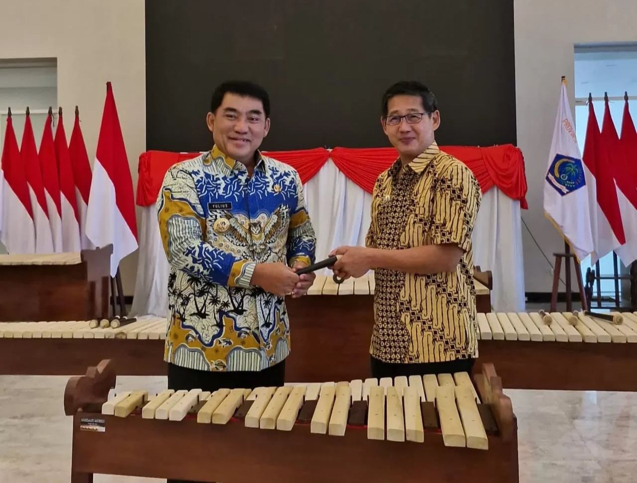 Gubernur Sulut Mayjen TNI (Purn) Yulius Selvanus saat menyerahkan alat musik Kolintang kepada Wali Kota Bitung Hengky Honadar.