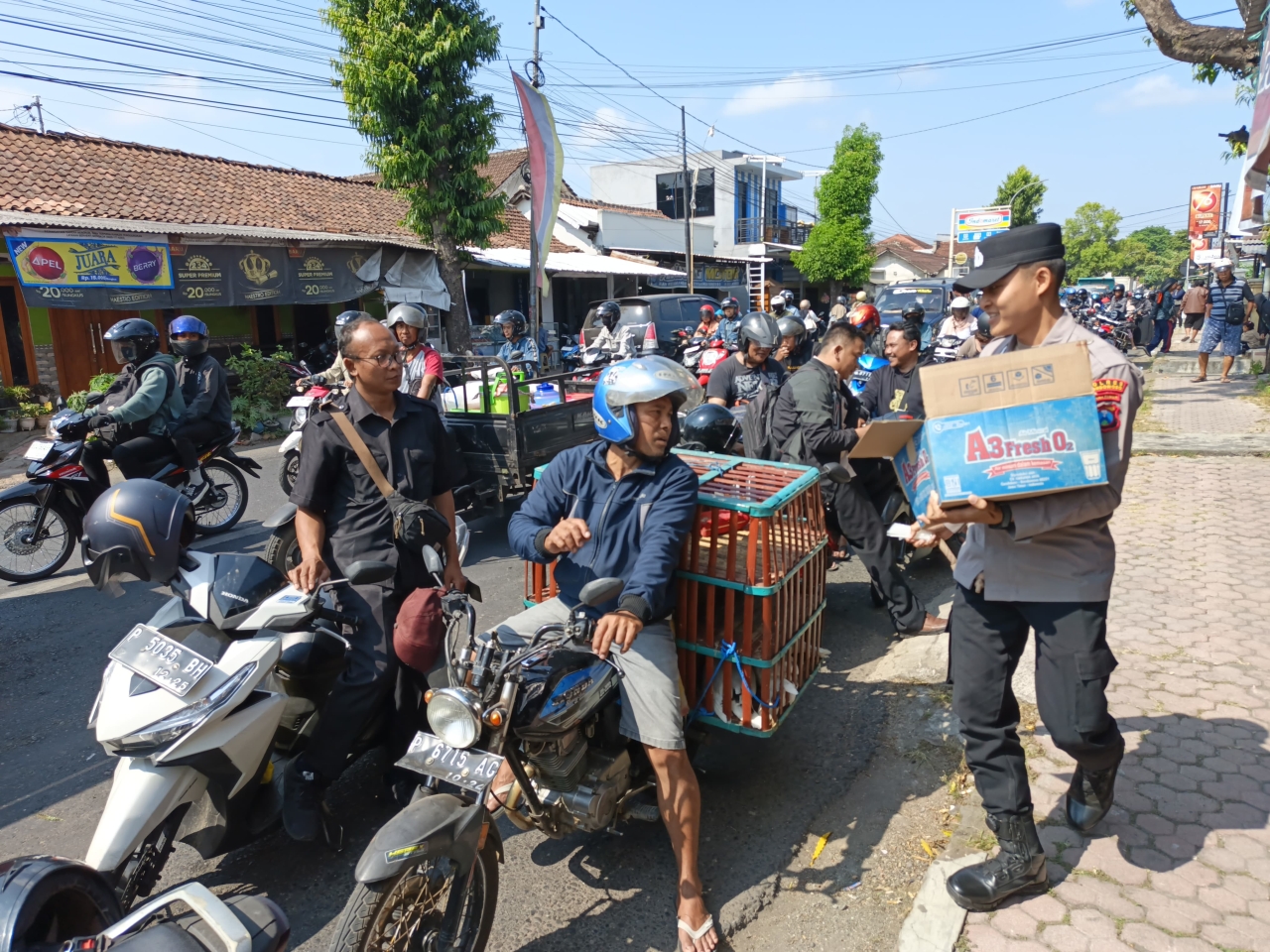 Polisi Peduli : Polres Bondowoso Berbagi Air Minum kepada Warga yang Antri di SPBU