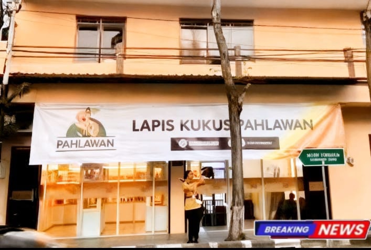 Caption: pegawai kue lapis kukus pahlawan cabang Sampang saat sigap menyapa pejalan kaki serta pengendara di trotoar.