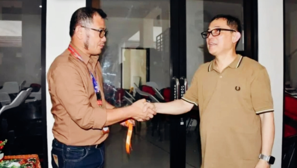 Rektor Unsrat, Oktovian Berty Alexander Sompie saat menyerahkan kunci simbolis penggunaan gedung kepada Dekan FISIP Unsrat, Ferry Daud Liando.