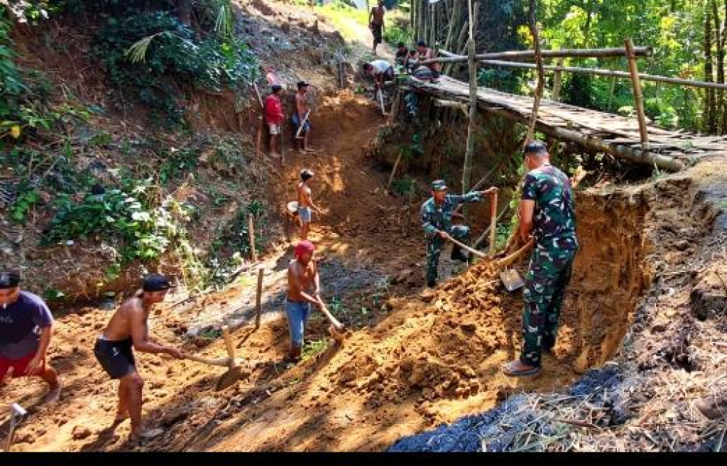 Caption Foto: Anggota Babinsa Posramil 0828/14 Karang Penang, Koptu Malik, bersama masyarakat Dusun Lembanah bahu-membahu mempercepat pembangunan Jembatan